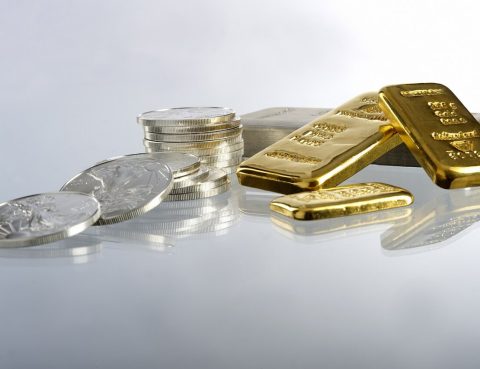 gold bars next to silver coins