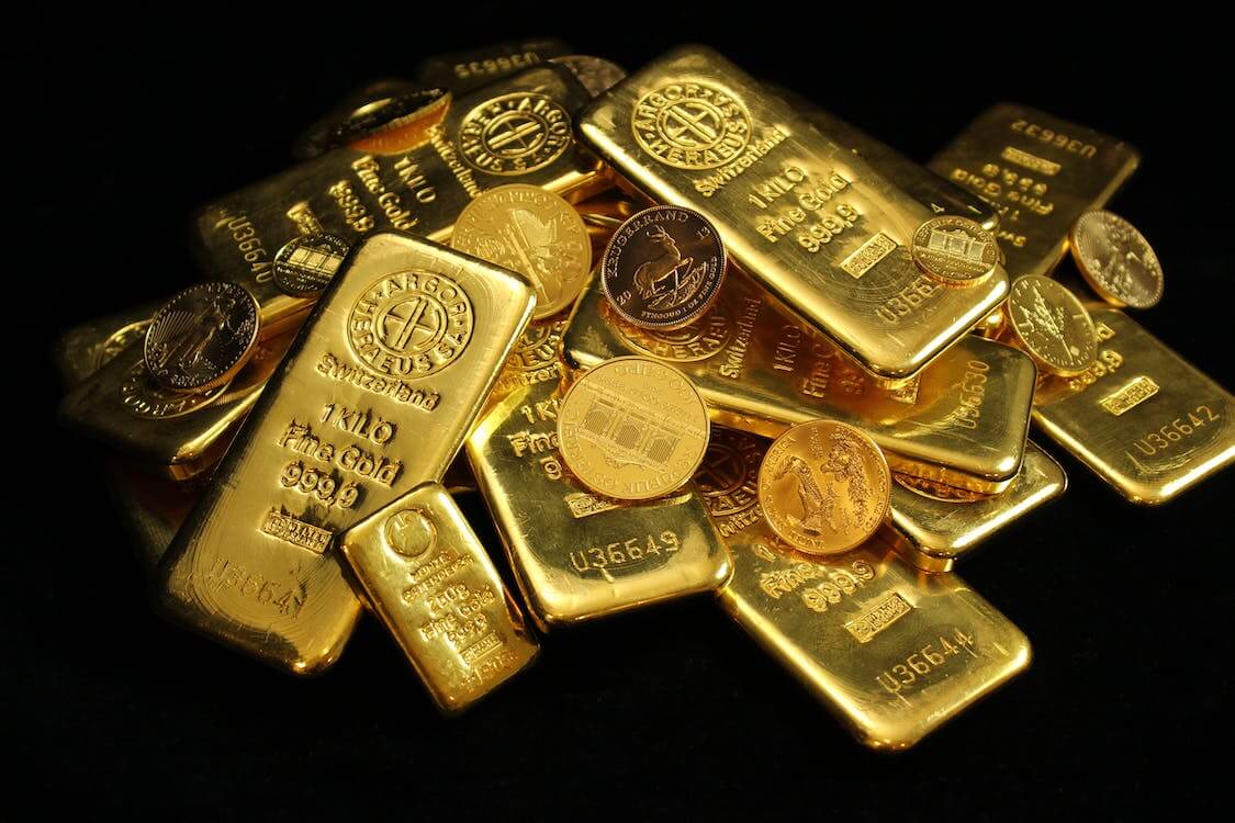 pile of gold coins and gold bars on black background