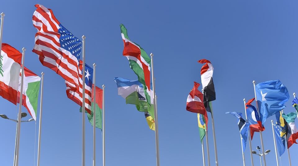 various national flags flying on flag poles